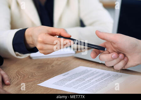 Business donna dando una penna per imprenditore pronto a firmare il contratto. Comunicazione di successo alla riunione o negoziazione Foto Stock