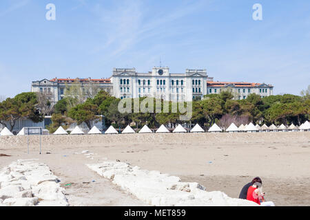 Ex luxury Grand Hotel des Bains, Lido di Venezia, Venezia, Veneto, Italia visto da un frangiflutti sulla spiaggia con un paio di seduta rilassante su th Foto Stock