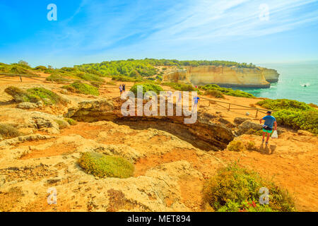 A Benagil, Portogallo - 23 agosto 2017: a Benagil Grotta visto dalla cima della scogliera di roccia in Costa Algarve, Lagoa, Portogallo. Persone che guardano il mare impressionanti grotte da sopra. Vacanze estive. Foto Stock