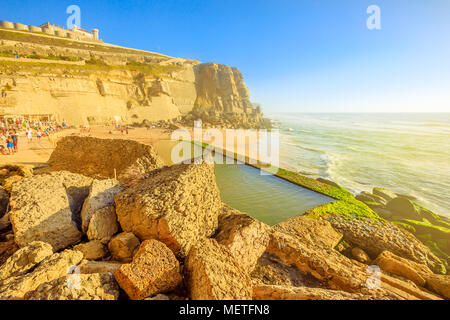 Promontorio panoramico e spiaggia a luce del sole di Azenhas do Mar con la famosa piscina naturale visibile con la bassa marea sull Oceano Atlantico in Portogallo. Portoghese popolare località balneare vicino a Colares e Sintra. Foto Stock