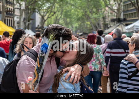 Barcellona, Spagna. 23 Aprile, 2018. Un giovane si vede mentre baciare nel mezzo della Ramblas di Barcellona. Catalunya celebra il 'Day di Sant Jordi ", il giorno di libri e di rose. Catalunya spera di raggiungere la cifra di 7 milione di rose venduto. È tradizione per dare una rosa o un libro tra gli appassionati. Numerosi autori letterari a firmare i loro libri al pubblico sulla strada. Credito: SOPA Immagini limitata/Alamy Live News Foto Stock