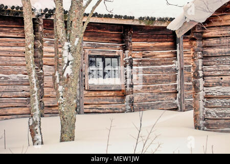 Vecchia fattoria in legno edifici sono coperti di neve in una fredda giornata invernale Foto Stock