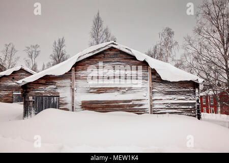 Vecchia fattoria in legno edifici sono coperti di neve in una fredda giornata invernale Foto Stock