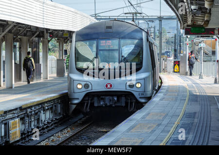 Cina, Shenzhen Lo Wu, Luohu, 2018-03-12: Fast treno metro arriva a open-air station, la gente a piedi sulla piattaforma. MTR Corporation Foto Stock