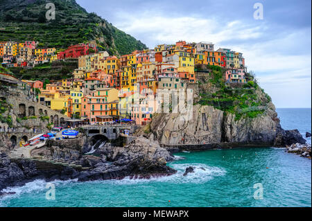 Case colorate appeso su una roccia nel pittoresco Manarola Vecchia città sul mare Mediterraneo costa, Cinque Terre, Liguria, Italia Foto Stock