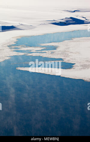 Thin Ice è una copertura di un lago. Wisps di haze sono in aumento a partire dai luoghi di aprire l'acqua. Foto Stock