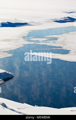 Thin Ice è una copertura di un lago. Wisps di haze sono in aumento a partire dai luoghi di aprire l'acqua. Foto Stock