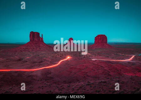 Classic vista panoramica di scenic Monument Valley con il famoso mezzoguanti e Merrick Butte con percorsi di luce durante la notte in estate, Arizona, America Foto Stock