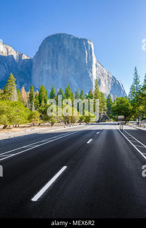 Famoso El Capitan picco di montagna con la strada che attraversa il Parco Nazionale di Yosemite Valley in bella la luce del mattino al sorgere del sole in estate, il Parco Nazionale di Yosemite, STATI UNITI D'AMERICA Foto Stock