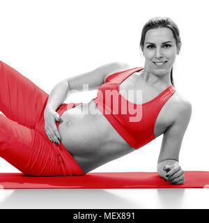 Portret della donna incinta in sportswear, isolato su bianco Foto Stock