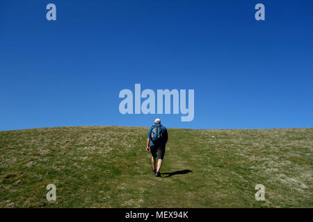 Lone Hillwalker maschio a piedi fino alla vetta di Wainwright Vertice di Binsey nel Parco Nazionale del Distretto dei Laghi, Cumbria, Inghilterra, Regno Unito. Foto Stock