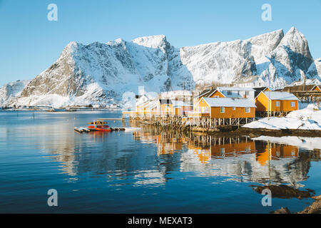 Scenic Isole Lofoten arcipelago paesaggio invernale con il tradizionale giallo pescatore cabine Rorbuer nello storico villaggio di Sakrisoy nei, Norvegia Foto Stock