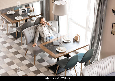 Allegro uomo rilassato al pranzo di lavoro Foto Stock