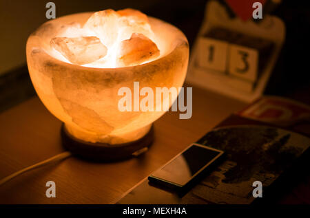 Lampada di sale sul tavolo di legno illuminatig il calendario e il lettore mp3. Girato in venerdì il tredicesimo Foto Stock