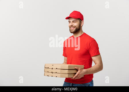 Concetto di consegna: giovani caucasici bello Pizza consegna uomo con scatole per pizza isolate su uno sfondo grigio Foto Stock