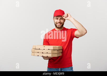 Concetto di consegna: giovani caucasici bello Pizza consegna uomo con scatole per pizza isolate su uno sfondo grigio Foto Stock