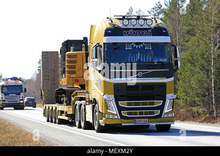 Giallo Volvo FH 500 carrello cale Cat 315FL escavatore idraulico sul rimorchio con collo d'oca lungo l'autostrada di primavera a Raasepori, Finlandia - 20 aprile 2018. Foto Stock