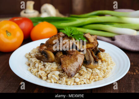 Orzo porridge, Prataioli fritti e fegato d'anatra, bollito uova di quaglia, pomodori e rucola - cibo sano. Foto Stock