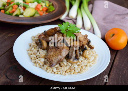 Orzo porridge, Prataioli fritti e fegato d'anatra, bollito uova di quaglia, pomodori e rucola - cibo sano. Foto Stock