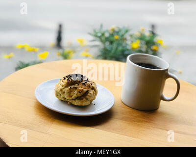 Pasticceria salata con semi di papavero servita con caffè al negozio del giardino esterno Street Food. Il panificio. Foto Stock