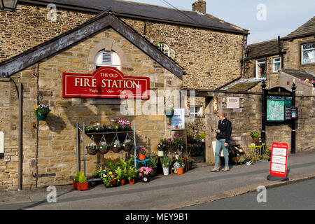 Donna visitare la vecchia stazione dei vigili del fuoco a Skipton, North Yorkshire, Regno Unito. Ora un multi-rivenditore capacità includente un cafe e il vivaio. Foto Stock