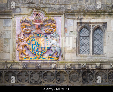 Dipinto stemma reale sulla parete al di sopra della high street gateway per il distretto della cattedrale medievale a Salisbury, Inghilterra. Foto Stock