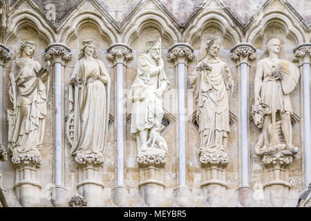 Statue scolpite (da sinistra, Sts Barbara, Katherine, Roche, Nicholas e George) esterno la parete ovest presso la cattedrale medievale della cattedrale di Salisbury. Foto Stock