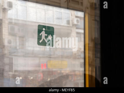 Immagine ravvicinata di un verde segno di uscita sul bus porta. Segnale di uscita sul vetro, finestra. Foto Stock