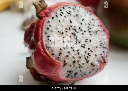 Close-up foto di fettine di pezzo di grandi pitaya frutta (dragonfruit) con nero semi. Foto Stock