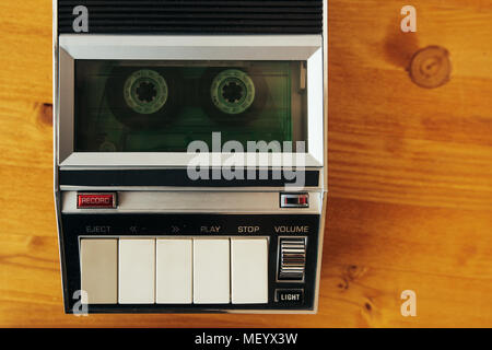 Cassetta Audio del nastro in laminazione vintage player sulla scrivania, vista dall'alto. Interrogatori della polizia la registrazione del suono retrò concetto di tecnologia per 1970s, 80s e Foto Stock