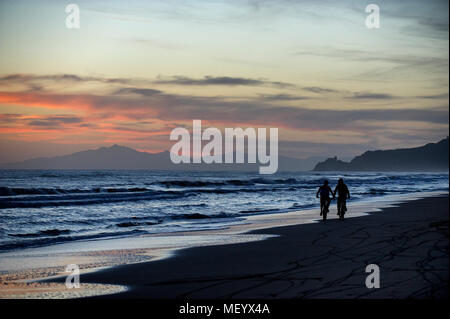 Due mountain bike giro in treno lungo la spiaggia vicino al porto di Punta Ala in Toscana, Italia al tramonto. Foto Stock