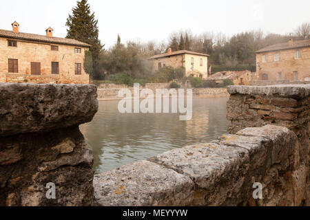 Nel centro di bagno Vignoni domina l'antica piscina termale. Oggi la piscina è un monumento protetto e qui è vietato fare il bagno. Ma il fascino del vecchio luogo di balneazione è perfettamente conservato. Numerosi caffè e ristoranti fiancheggiano il sito storico, che spesso è stato lo sfondo per i film. Foto Stock