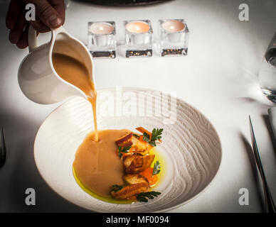 Tradizionale zuppa polacca di patate con prosciutto, patate al forno e olio di erbe e un tuorlo d'uovo a 62 gradi. Pranzo Dish in Hotel Blow up 5050, Posen Foto Stock