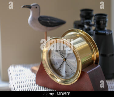 Immagine del clock in ottone, statua di uccelli e binocoli. Foto Stock