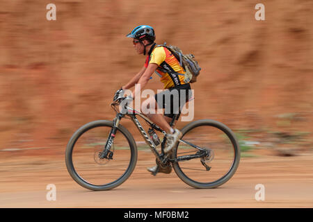 Il panning shot di biker contro uno sfondo semplice durante il PCC specializzati corsa presidenziale Mountain bike la concorrenza 2013 a Semenyih, Malaysia. Foto Stock