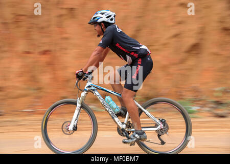 Il panning shot di biker contro uno sfondo semplice durante il PCC specializzati corsa presidenziale Mountain bike la concorrenza 2013 a Semenyih, Malaysia. Foto Stock