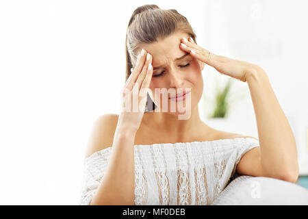 Immagine di donna che soffre di mal di testa a casa Foto Stock