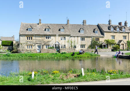 Fila di graziosi cottage sulla riva del fiume occhio nel grazioso villaggio Costwold di macellazione inferiore nel Gloucestershire, Regno Unito Foto Stock