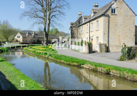 Fila di graziosi cottage sulla riva del fiume occhio nel grazioso villaggio Costwold di macellazione inferiore nel Gloucestershire, Regno Unito Foto Stock