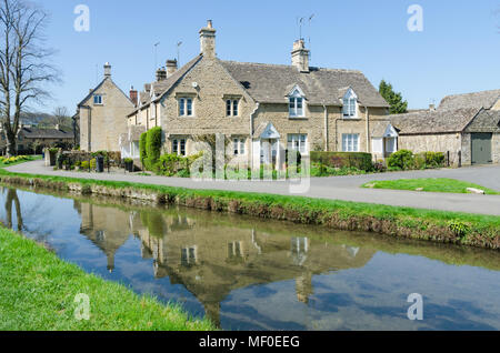 Fila di graziosi cottage sulla riva del fiume occhio nel grazioso villaggio Costwold di macellazione inferiore nel Gloucestershire, Regno Unito Foto Stock