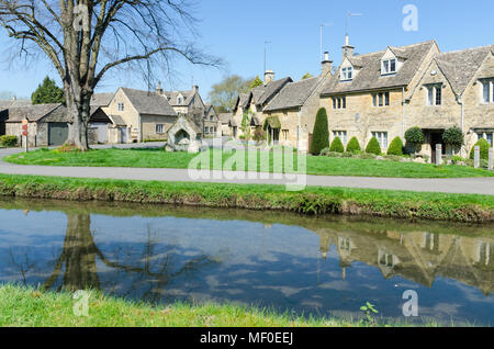 Fila di graziosi cottage sulla riva del fiume occhio nel grazioso villaggio Costwold di macellazione inferiore nel Gloucestershire, Regno Unito Foto Stock