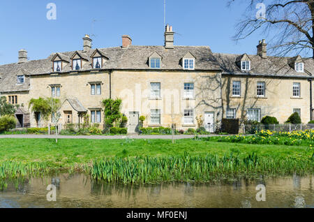 Fila di graziosi cottage sulla riva del fiume occhio nel grazioso villaggio Costwold di macellazione inferiore nel Gloucestershire, Regno Unito Foto Stock