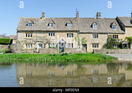 Fila di graziosi cottage sulla riva del fiume occhio nel grazioso villaggio Costwold di macellazione inferiore nel Gloucestershire, Regno Unito Foto Stock