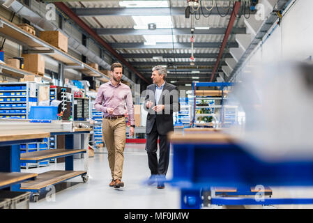 Uomini d'affari durante la riunione nella sala di produzione Foto Stock