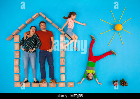 I genitori in piedi in casa, mentre i bambini giocano in giardino Foto Stock
