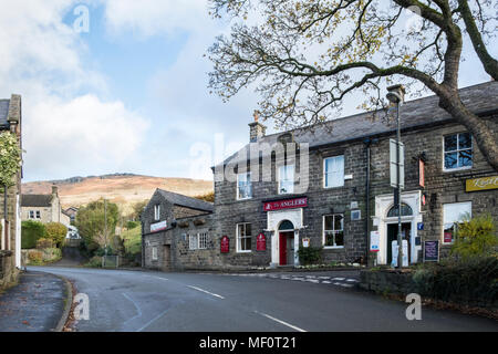 The Anglers pub nel villaggio di Bamford con Bamford bordo nella distanza che si eleva al di sopra del villaggio, Derbyshire, Peak District, England, Regno Unito Foto Stock