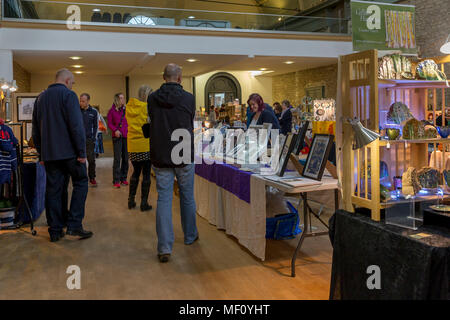 Gli amanti dello shopping a piedi attorno al mercato coperto guardando le bancarelle di artigiani nel mercato di mais, Cirencester, Gloucestershire, England, Regno Unito Foto Stock