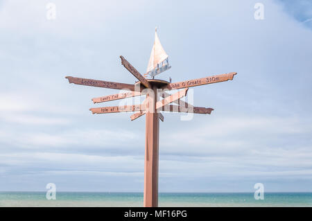 Direzione turistica & segni a distanza montata sul montante con banderuola sulla parte superiore, situato su shorefront in Port william, Dumfries & Galloway, Scotland, Regno Unito Foto Stock