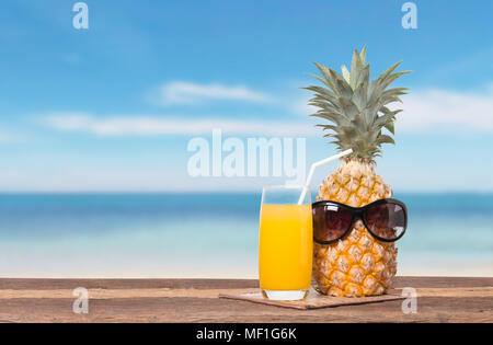 Succo di ananas e polpa sulla spiaggia la tabella e il blu del cielo per il concetto di estate Foto Stock