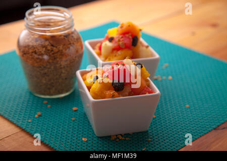 Insalata di frutta mix di melone, banana, anguria, arancio e ananas in una piccola ciotola di porcellana, prima colazione o snack sani, il concetto di perdita di peso Foto Stock